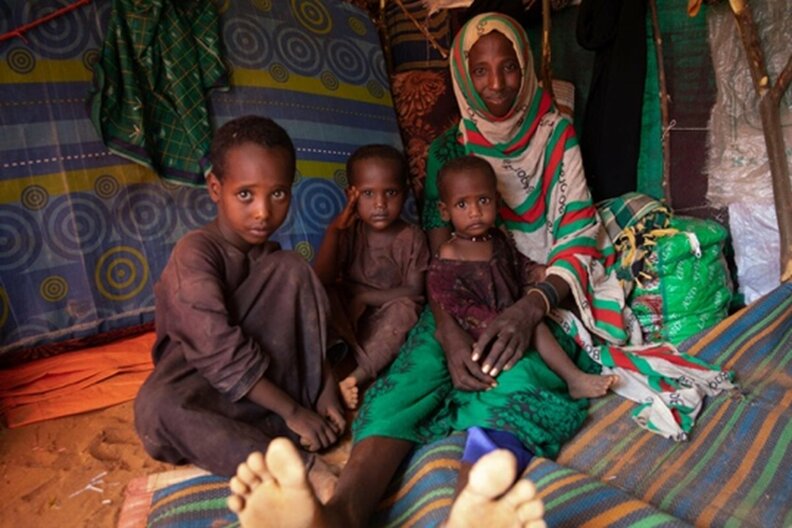 Somalie. Mido (25 ans) avec trois de ses quatre enfants dans leur abri au camp de déplacés qui les abrite actuellement. La famille reçoit des suppléments nutritionnels du PAM. | ©PAM/Samantha Reinders