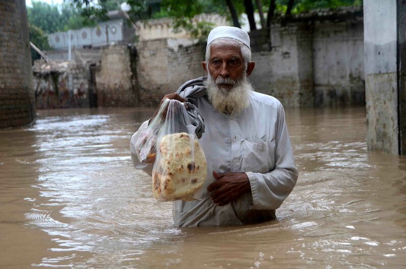 Un homme traverse à gué une zone inondée à Peshawar, Khyber Pakhtunkhwa, Pakistan. Des milliers de personnes vivant dans des zones menacées d'inondation ont reçu l'ordre d'évacuer. Hussain Ali / Agence Anadolu Hussain Ali / AGENCE ANADOLU / Agence Anadolu via AF