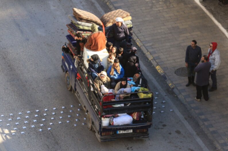 A family with their belongings flee their village in Southern Lebanon riding in the back of a truck. © AFP/ Mahmoud Zayyat