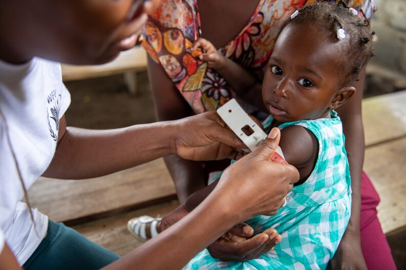 En Haïti, une jeune fille subit un test de dépistage de la malnutrition aiguë : on mesure la circonférence de son bras © PAM/Theresa Piorr