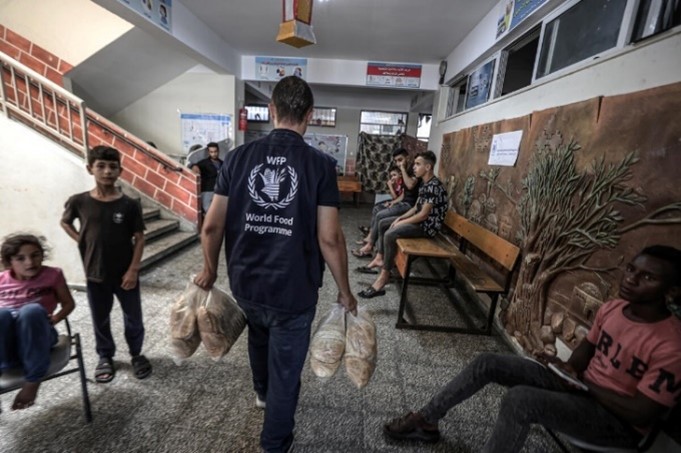 Palestine. Distribution de pain du PAM dans une école affiliée à l'Office de secours et de travaux des Nations Unies pour les réfugiés de Palestine (UNRWA), identifiées pour servir d’abri aux populations en cas d’urgence 