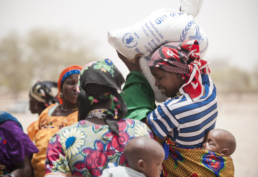 woman carrying a WFP bag with essential goods