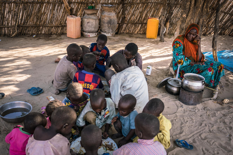 Une bénéficiaire de l’assistance du PAM au Tchad regarde ses petits-enfants manger. PAM/Evelyn Fey
