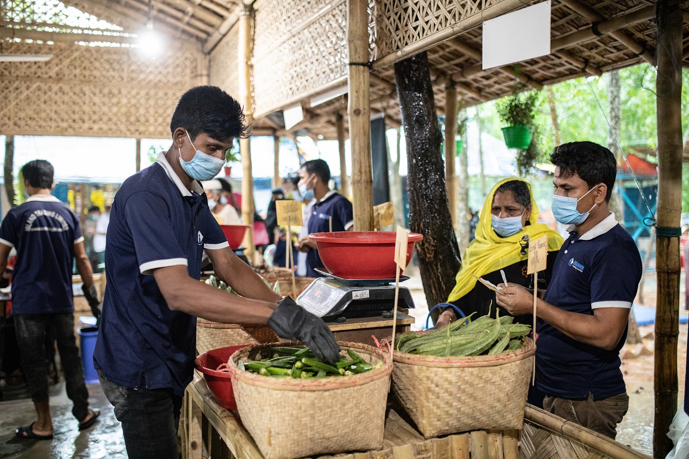 PAM/Nihab Rahman. Des bénéficiaires paient des produits alimentaires dans un marché au Bangladesh.