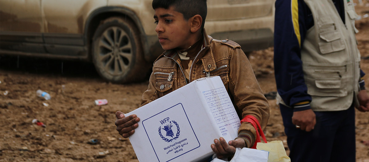 Boy carrying WFP food assistance