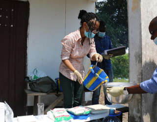 Louise Abayomi, chargée de recherche principale (postrécolte) au Département Alimentation et marchés, prépare le fufu à échantillonner et montre à l'équipe congolaise comment doser la bonne quantité de farine, d'eau et de nutriments. Photo : PAM/Alice Rahmoun
