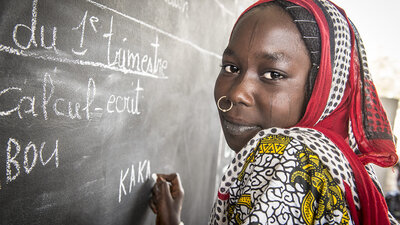 Kaka Marabou écrit son nom sur le tableau de l'école de Yakoua, au lac Tchad. Les réfugiés, les personnes déplacées et les autres communautés vulnerables du bassin du lac Tchad dépendent de l'aide humanitaire pour survivre et l'accès à l'éducation de base est également limité. PAM/Giulio d'Adamo