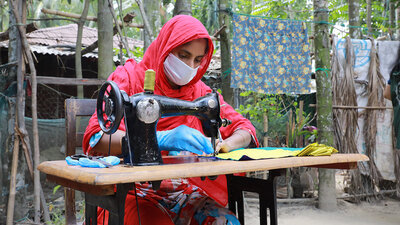 Pendant la pandémie de covid-19, à Cox's Bazar, au Bangladesh, le PAM s'est engagé avec des femmes de la communauté d'accueil et des réfugiés rohingyas, par le biais de son programme d’existence, à fabriquer des masques qui ont été distribués par le gouvernement local et les agences humanitaires, en leur donnant une allocation mensuelle, une formation à un emploi commercialisable et des connaissances financières, ainsi qu'une bourse pour démarrer une entreprise. PAM/Nalifa Mehelin