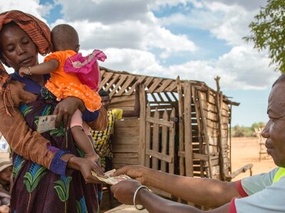 a woman is receiving money when she holds her baby