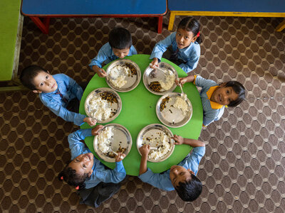 Un groupe d’écoliers prend son repas scolaire.