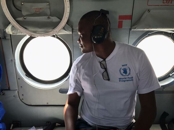 man in white WFP t-shirt looks out of helicopter window