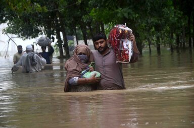 Hussain Ali / Anadolu Agency Displaced people wade through a flooded area in Peshawar, Khyber Pakhtunkhwa. Since June, nearly 900 people have died by severe monsoon rains and floods in Pakistan, while thousands have been displaced and millions more affected.