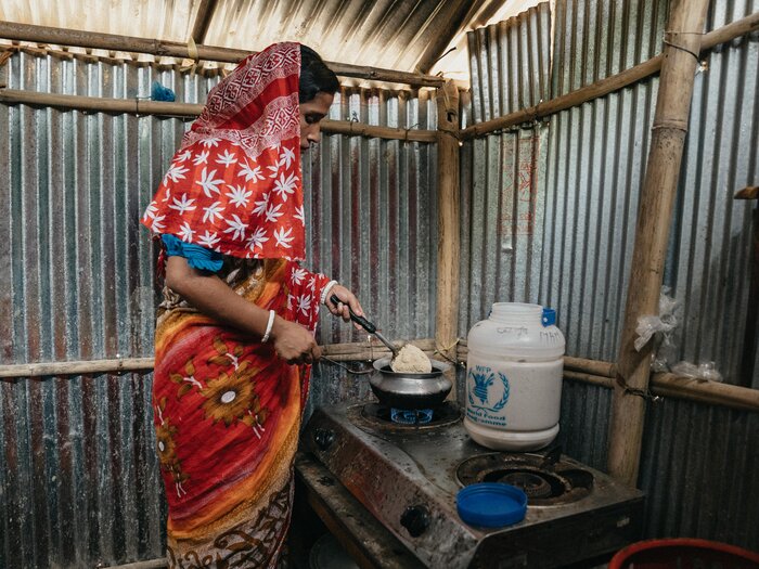 Une femme cuisine des aliments fournis par le PAM