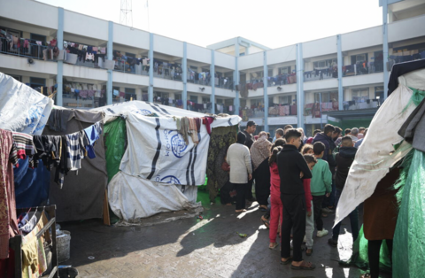 A crowd of people standing near tents