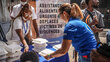 A woman in a WFP blue shirt and a woman in a white T-shirt prepare to distribute hot meals at a location in Haiti