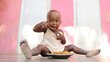 A little girl, Leny Previlon, eats lunch - a plate of rice, chicken and vegetable stew - on the floor of her aunt's house terrace in Gonaives, Haiti.