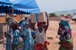 Photo : PAM/Musa Abema. Une femme qui vient de recevoir de l'aide transporte une boîte de biscuits sur la tête à Sange, dans le territoire d'Uvira, en province du Sud-Kivu, en République démocratique du Congo.
