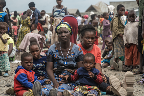 Photo du PAM/Michael Castofas. Une mère et ses enfants déplacés par la violence attendent de s'inscrire auprès de SCOPE pour recevoir les premières aides. Elle vit dans le camp de Rusayo, près de Goma, depuis novembre 2023.