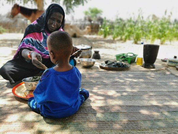 WFP/Maria Gallar, Fatime nourrit son fils. 