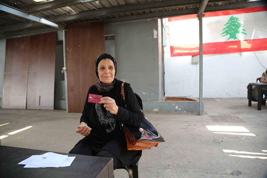 A Lebanese woman hold cash assistance card at a WFP distribution centre in Beirut.