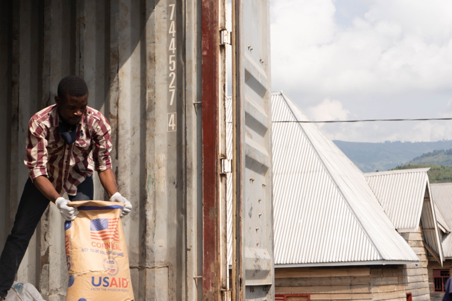 A man handles a bag of food provisions from USAID.