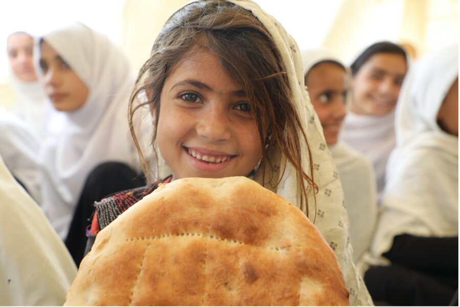 WFP is designing programmes to support Afghanistan's smallholder farmers and feeding children at the same time. In the picture, a girl holds a piece of bread from the Bread+ project, which gives children midday snacks and will grow to work with 1100 local bakers. Photo: WFP/Sadeq Naseri