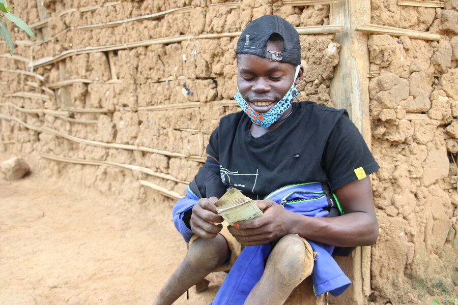 In restive eastern DRC, Sadi counts his WFP cash assistance. Photo: WFP/Benjamin Anguandia