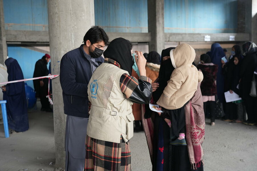 A woman and her child receive WFP food assistance in Kabul province. Women and girls have been hardest hit by Afghanistan’s hunger crisis. Photo: WFP/Sadeq Naseri