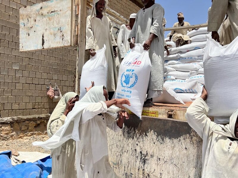 men offloading bags of WFP food from a truck in Sudan