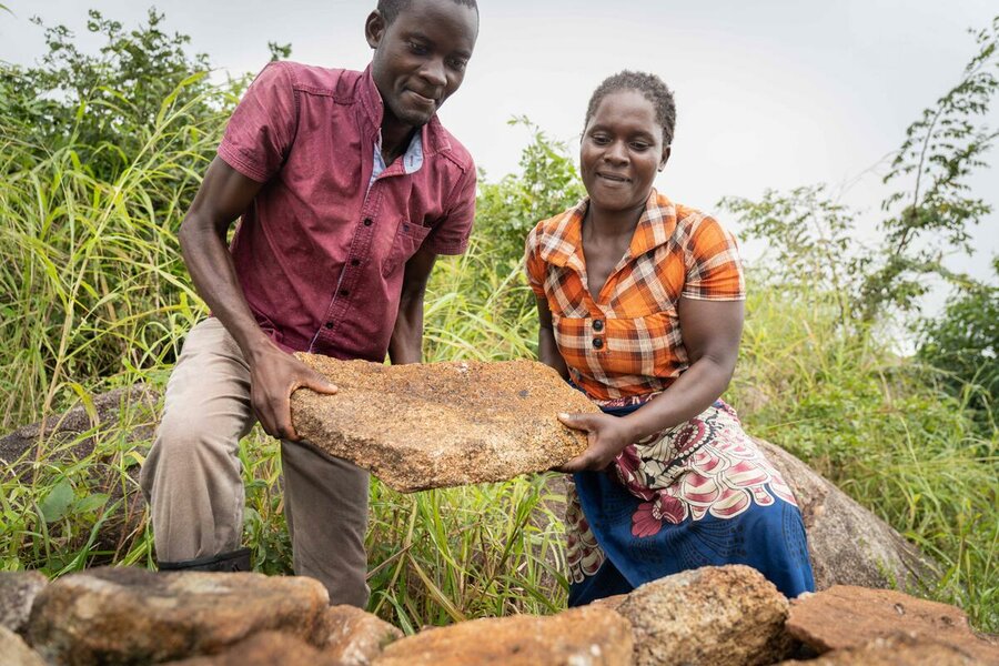 In Chigwirigwidi, Phalombe district, Malawi, Josephine is assisted in reinforcing a bund, built as part of a WFP-backed project, that protected her home from Cyclone Freddy. Photo: WFP/Badre Bahaji