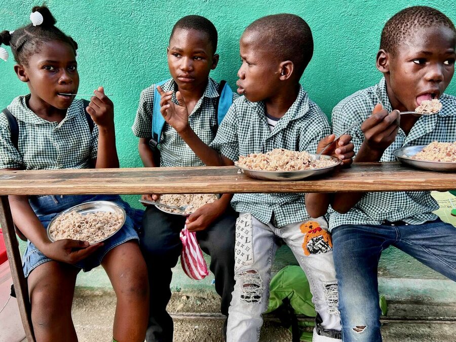 Children eat a WFP school meal in Haiti's violence-torn Cite Soleil. Photo: WFP/Jonathan Dumont