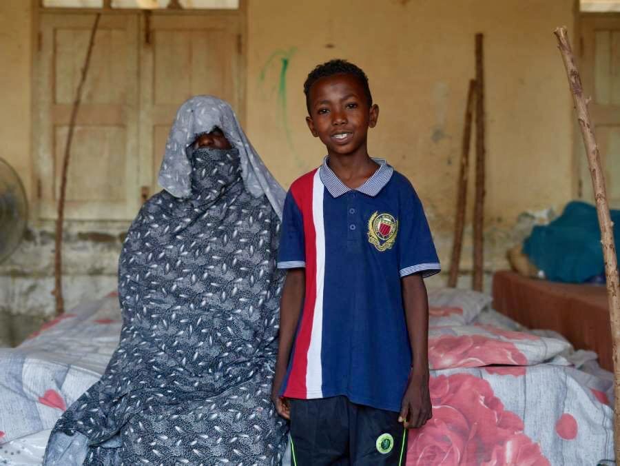 Ahmed and his mother Fatimmah in their makeshift bedroom they share with other family members. Photo: WFP/Leni Kinzli