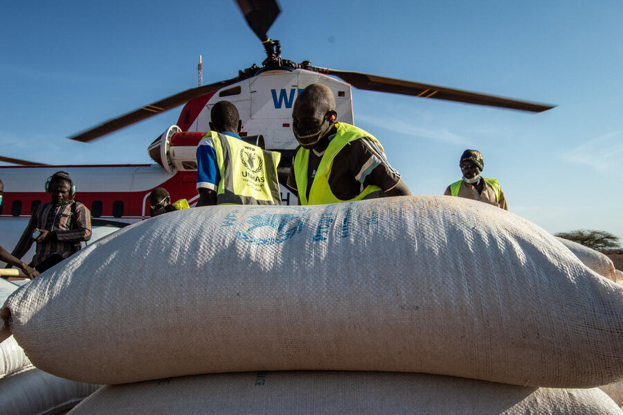 Bags of food from WFP are unloaded from a helicopter