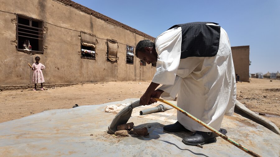 Abu Sufian fixes a water source at the Kassala displacement camp where he lives. As in his pre-war days he's taken a leadership role in the community. WFP/Leni Kinzli