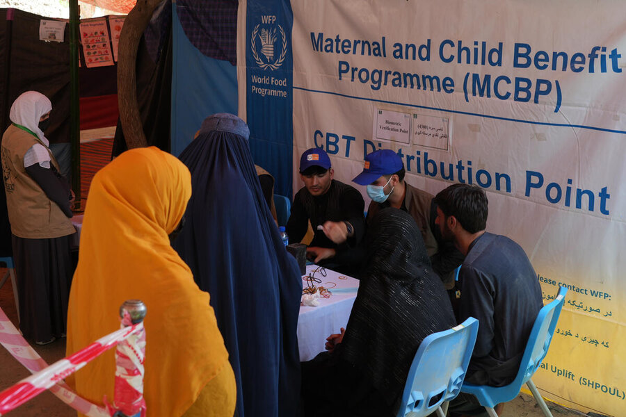 Afghan women in long headscarves and robes line up for WFP assistance. Photo: WFP/Philippe Kropf