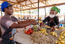 PAM/Andy Higgins. Zambie. Mulumbwa, une réfugiée de RDC sert un client à son étal au marché.