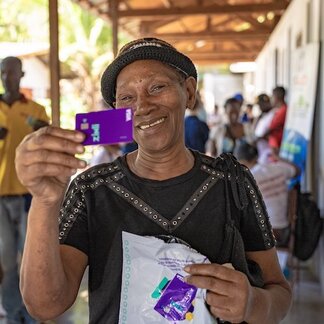 Un homme présente une carte pour un transfert monétaire électronique.