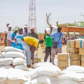 Les bénéficiaires reçoivent l'aide alimentaire du PAM dans des sacs et des boîtes.