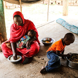 Une maman et ses deux enfants mangent ensemble