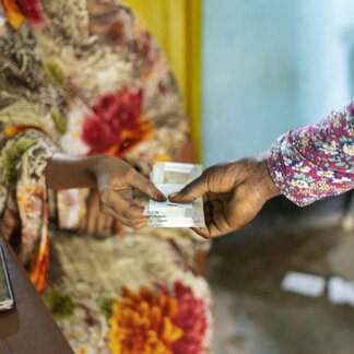 Femme recevant une aide en espèces de la part du personnel du PAM