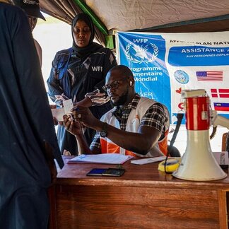 Le personnel du PAM enregistre des personnes déplacées sur un site d’assistance, vérifiant les documents d’identité et coordonnant les opérations de secours au Mali.