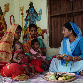 Des femmes partagent un repas avec leurs enfants.