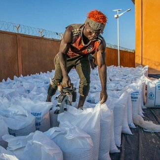 Un homme remballe de la nourriture du PAM