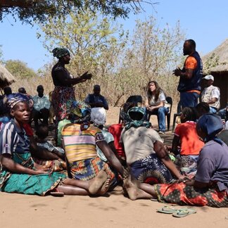 Des représentants de l'USAID et du PAM discutent avec la communauté affectée de Malassa, dans le district de Macate, province de Manica.