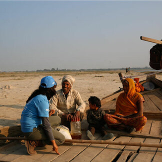 WFP staff talking to a man, his wife, and their child.