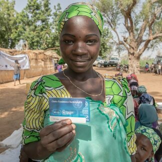 Femme présente sa carte de bons d'achat alimentaire. Photo: PAM/Simon Pierre Diouf