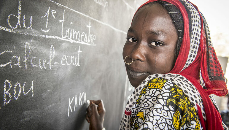 Kaka Marabou écrit son nom sur le tableau de l'école de Yakoua, au lac Tchad. Les réfugiés, les personnes déplacées et les autres communautés vulnerables du bassin du lac Tchad dépendent de l'aide humanitaire pour survivre et l'accès à l'éducation de base est également limité. PAM/Giulio d'Adamo